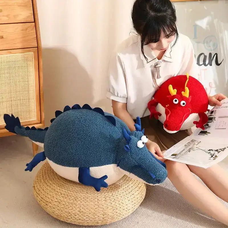 Child cuddling a fat dragon plush toy soft stuffed animal