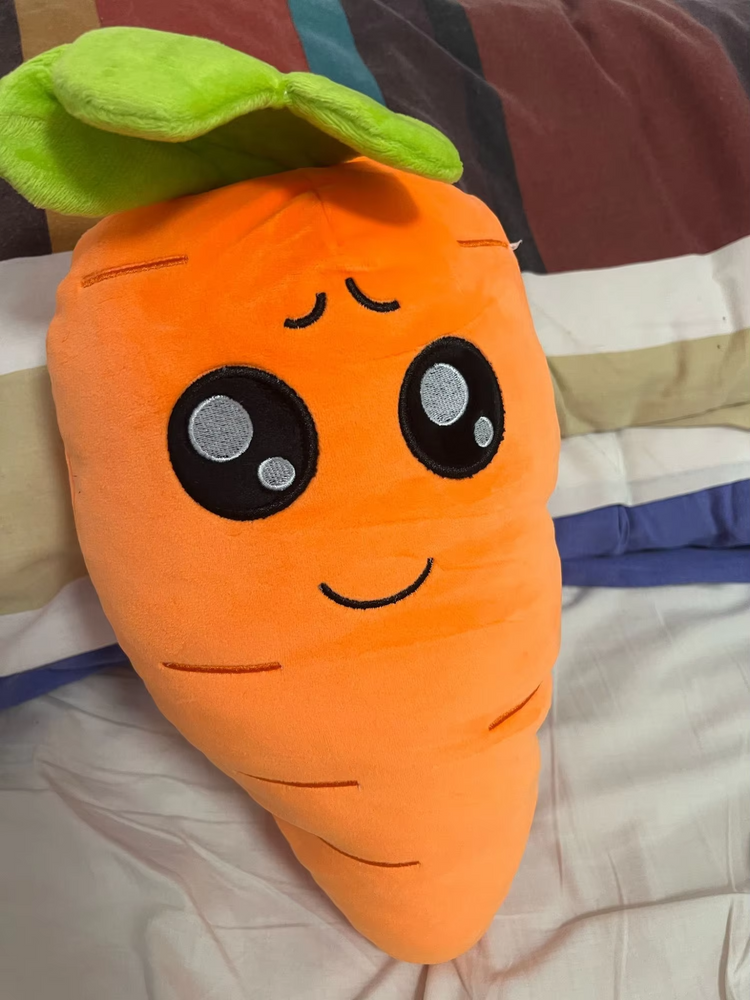 Orange carrot plush with a cute face.
