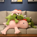 A stack of pink and green plush dinosaur toys piled on each other.