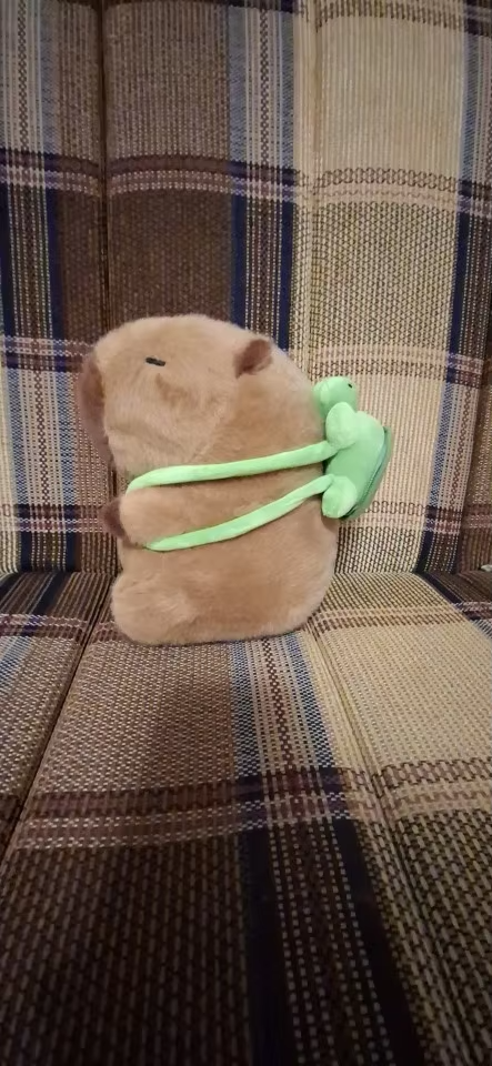 Stuffed capybara with green frog.