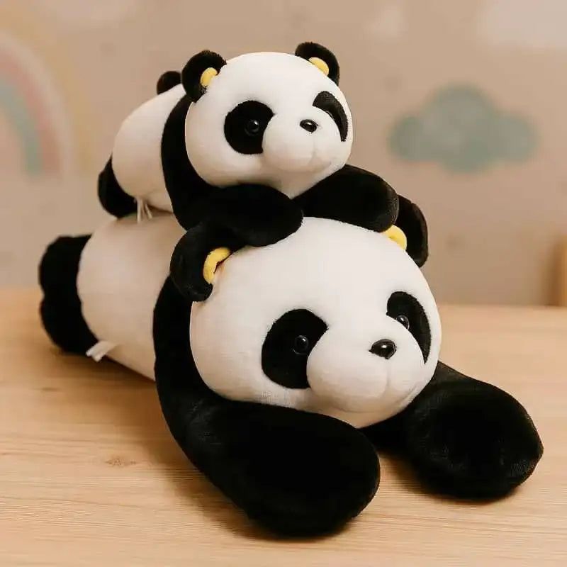 Two plush panda toys, one lying on its back and the other resting atop it, both featuring soft black-and-white fur with yellow accents around their ears.